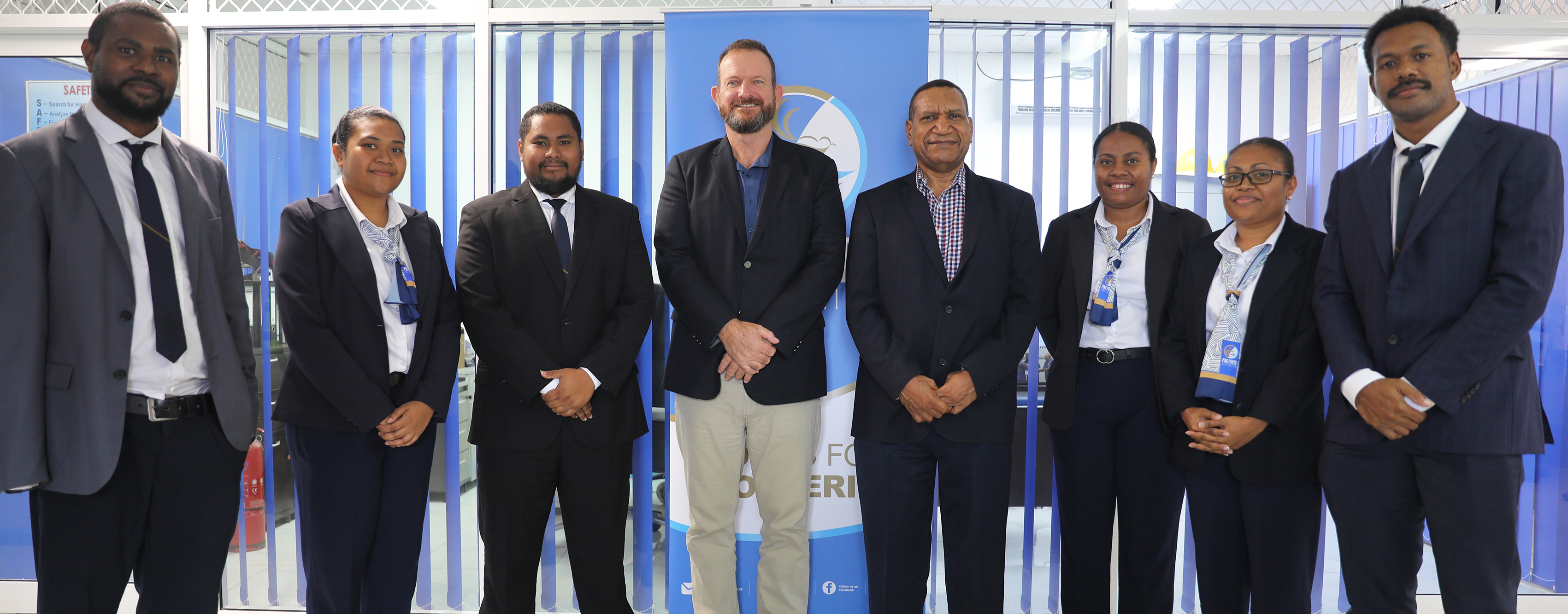 CEO, Neil Papenfus (center), PNG Ports Board Chairman, Harvey Nii (center-right) and Port Moresby-based graduates after their case study presentation